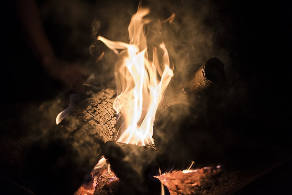 Bright flames rising from burning wood against the dark